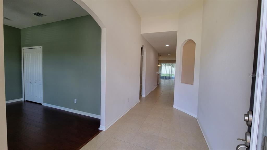 A tiled entryway leads to a hallway with an arched niche and a green-walled room — 2229 VALTERRA VISTA WAY, VALRICO, FL