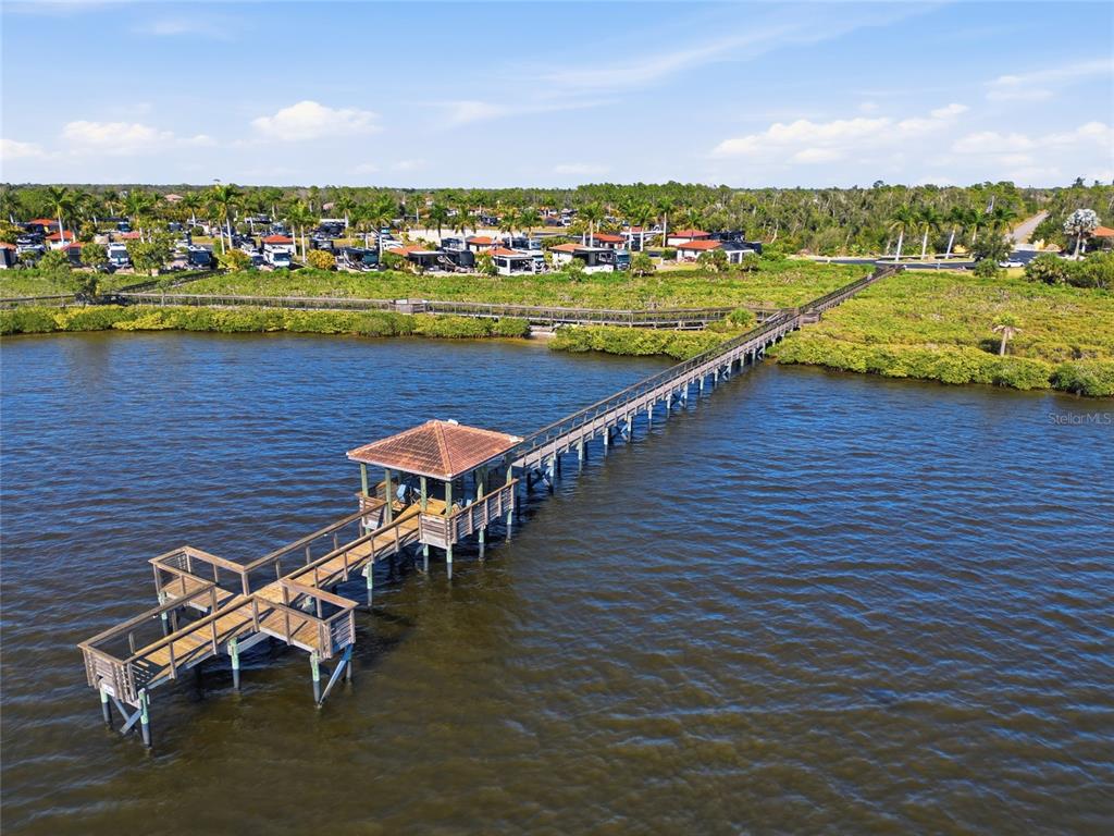 An aerial view shows a long wooden pier with a gazebo extending into the water — 14100 MYAKKA AVENUE UNIT 26, PORT CHARLOTTE, FL