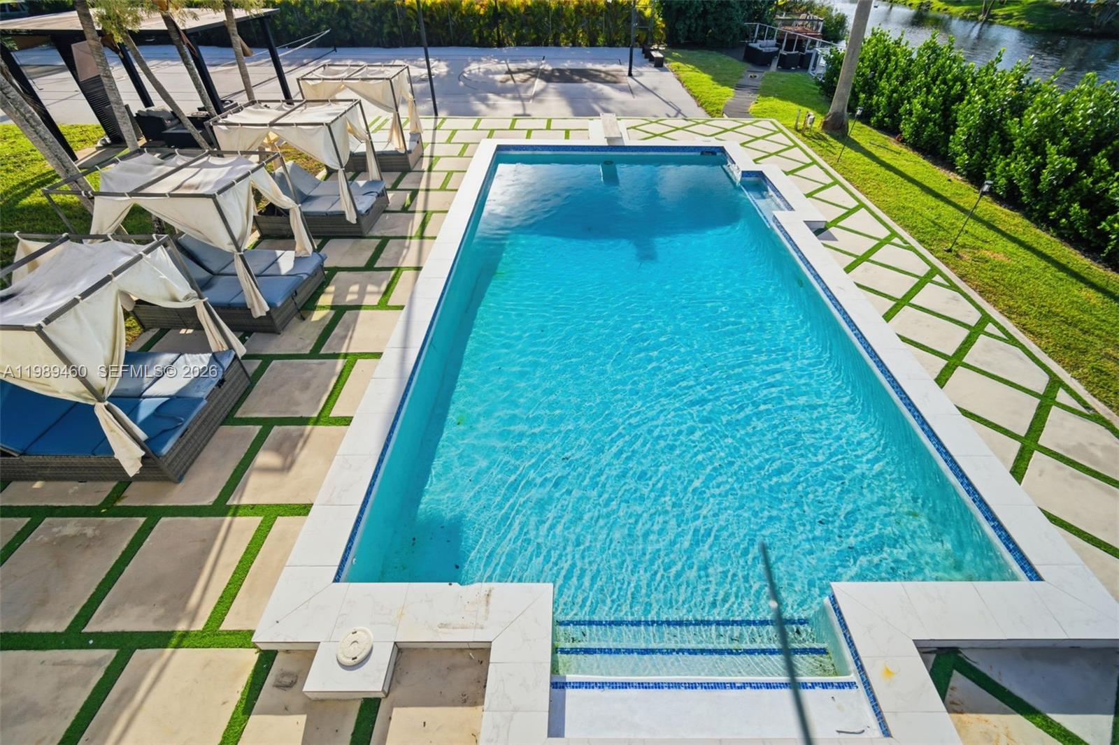 An aerial view shows a rectangular swimming pool surrounded by paved patio and lounge chairs — 2201 SW 115th Ter, Davie FL 33325, DAVIE, FL