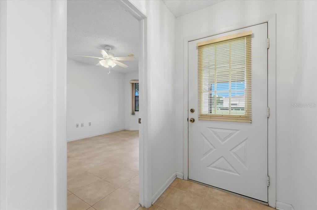 An entryway with tile flooring leads to a room featuring a ceiling fan — 3741 INNISBROOK DRIVE, LAKELAND, FL