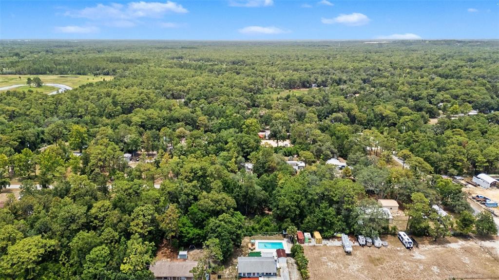 An aerial view shows a house with a swimming pool surrounded by dense forest — 7078 W LINCOLN LANE, HOMOSASSA, FL