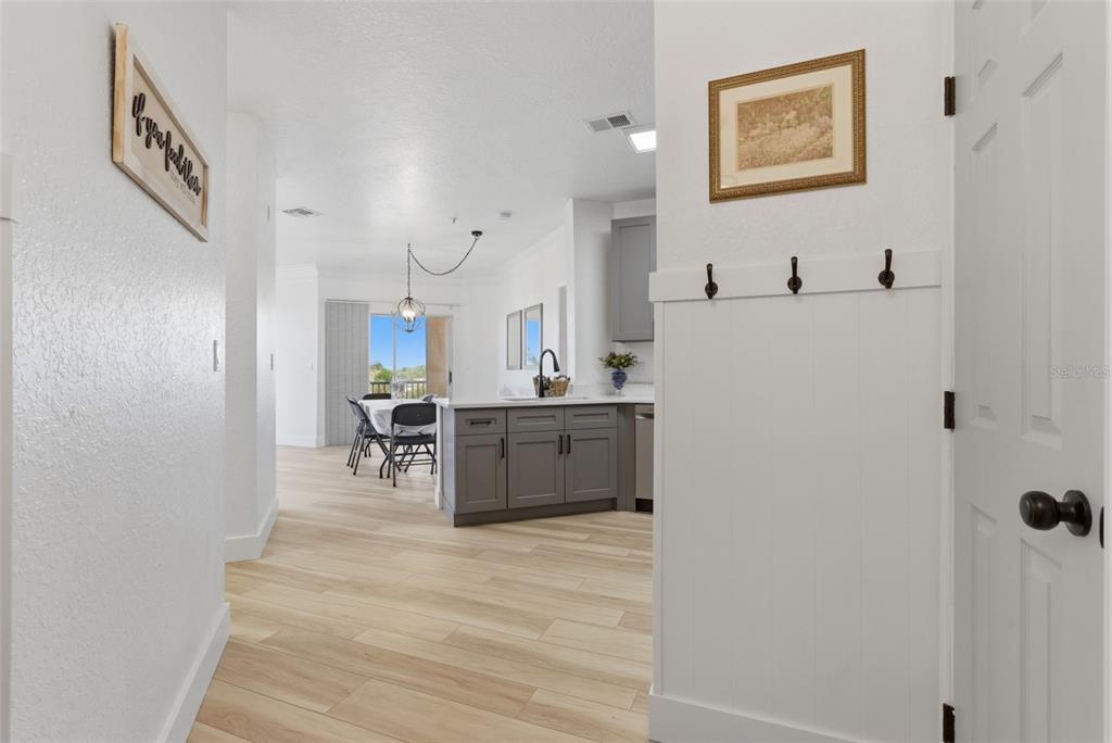 A view from a hallway looking into a kitchen with gray cabinets and a dining area — 4323 BAYSIDE VILLAGE DRIVE UNIT 312, TAMPA, FL