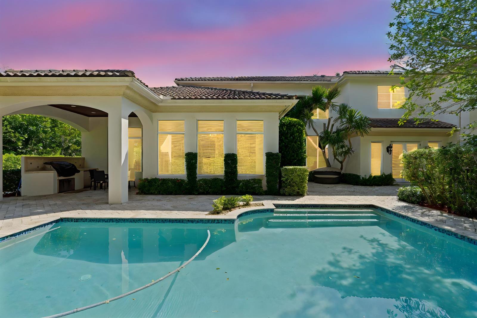 A backyard swimming pool sits in front of a two-story house with a covered patio — 4102 S Ocean Boulevard, Highland Beach FL 33487, HIGHLAND BEACH, FL