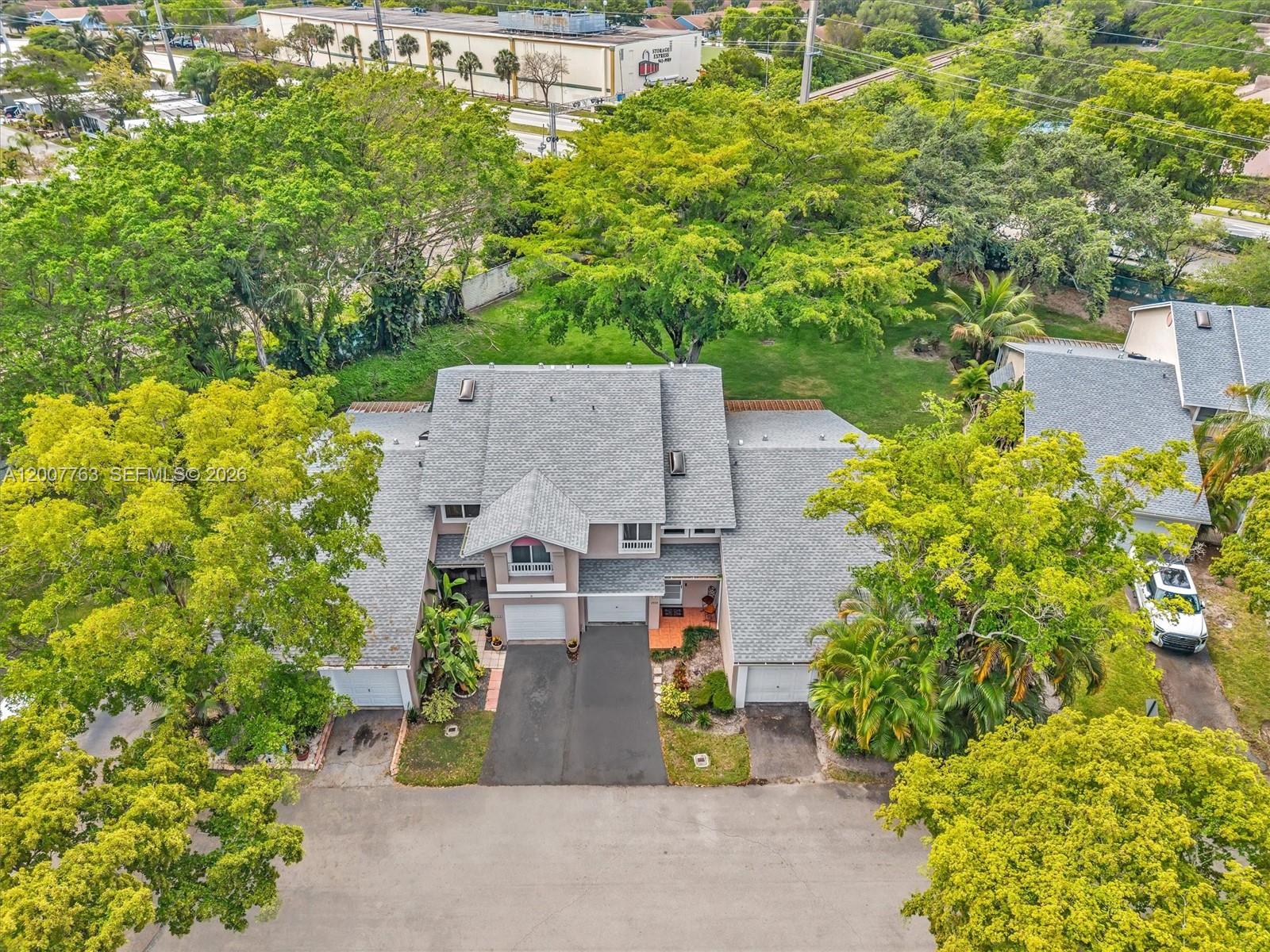 An aerial view shows a multi-unit residential building with gray shingled roofs and driveways — 1958 E Discovery Cir E, Deerfield Beach FL 33442, DEERFIELD BEACH, FL