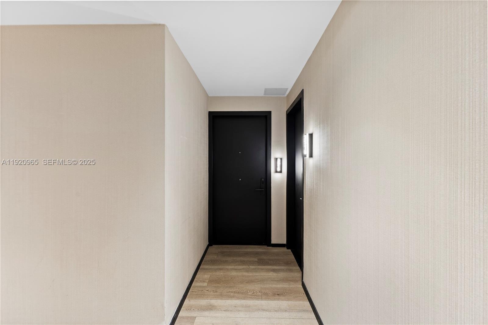 A narrow hallway features light-colored walls, wood-look flooring, and two dark doors — 398 NE 5th St # 3515, Miami FL 33132, MIAMI, FL