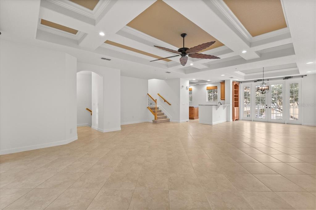 A spacious living room features a coffered ceiling, tile flooring, and a staircase — 1125 BOLTON PLACE, LAKE MARY, FL