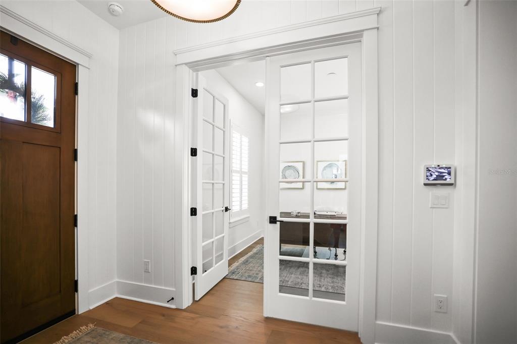 A foyer features white vertical wall paneling, hardwood floors, a wooden door, and French doors — 876 44TH AVENUE N, ST PETERSBURG, FL