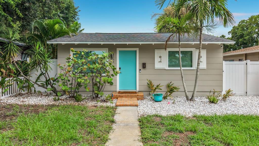 A single-story house with a turquoise front door, light-colored siding, and a white fence — 5458 6TH AVENUE N, ST PETERSBURG, FL
