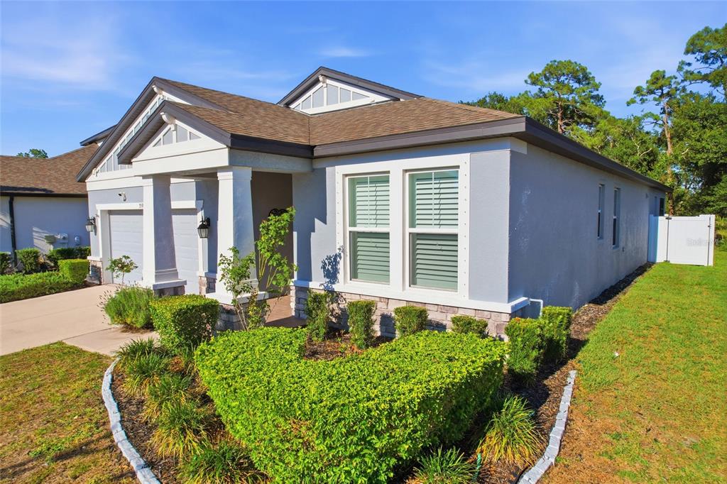 A single-story house with a gray stucco exterior, stone accents, and a covered front porch — 3590 SECRET STROLL DRIVE, SARASOTA, FL