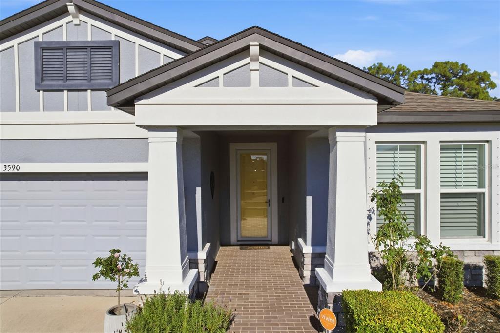 A front exterior view of a house featuring a brick walkway leading to the entrance — 3590 SECRET STROLL DRIVE, SARASOTA, FL