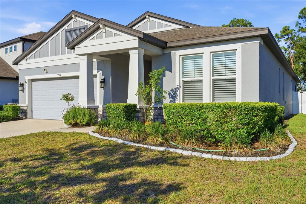 A single-story house with a gray exterior, white trim, a two-car garage, and landscaped yard — 3590 SECRET STROLL DRIVE, SARASOTA, FL