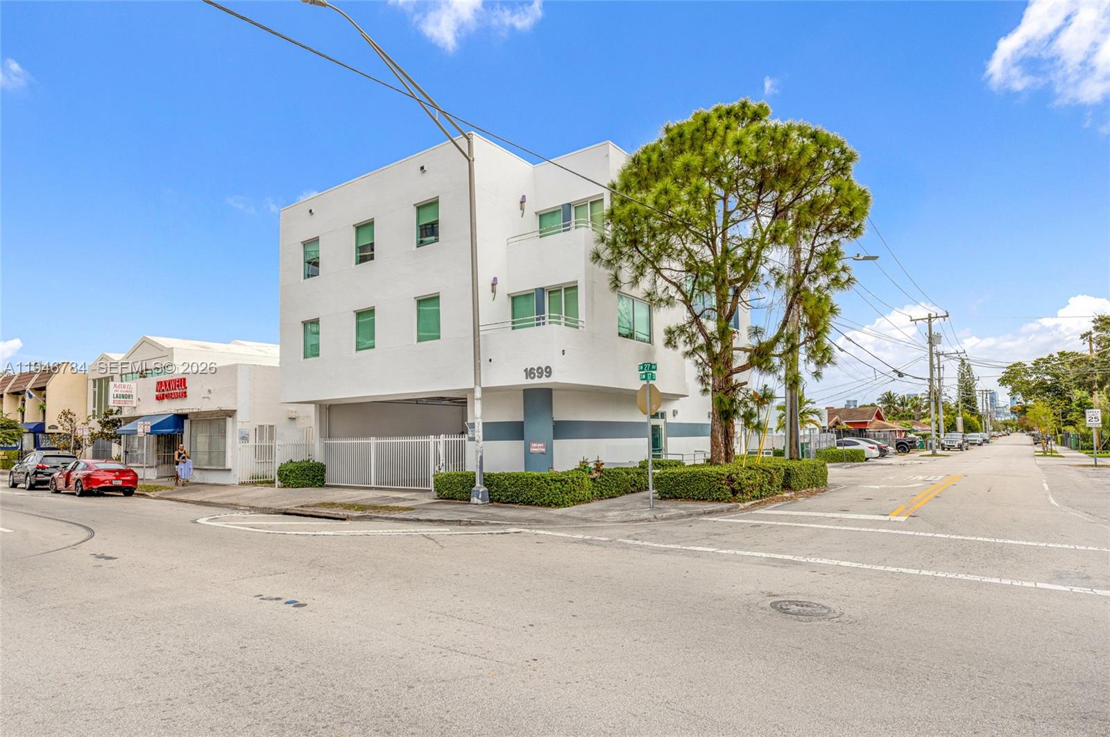 A three-story white building stands on a street corner with a large tree in front — 1693 SW 27th Ave, Miami FL 33145, MIAMI, FL