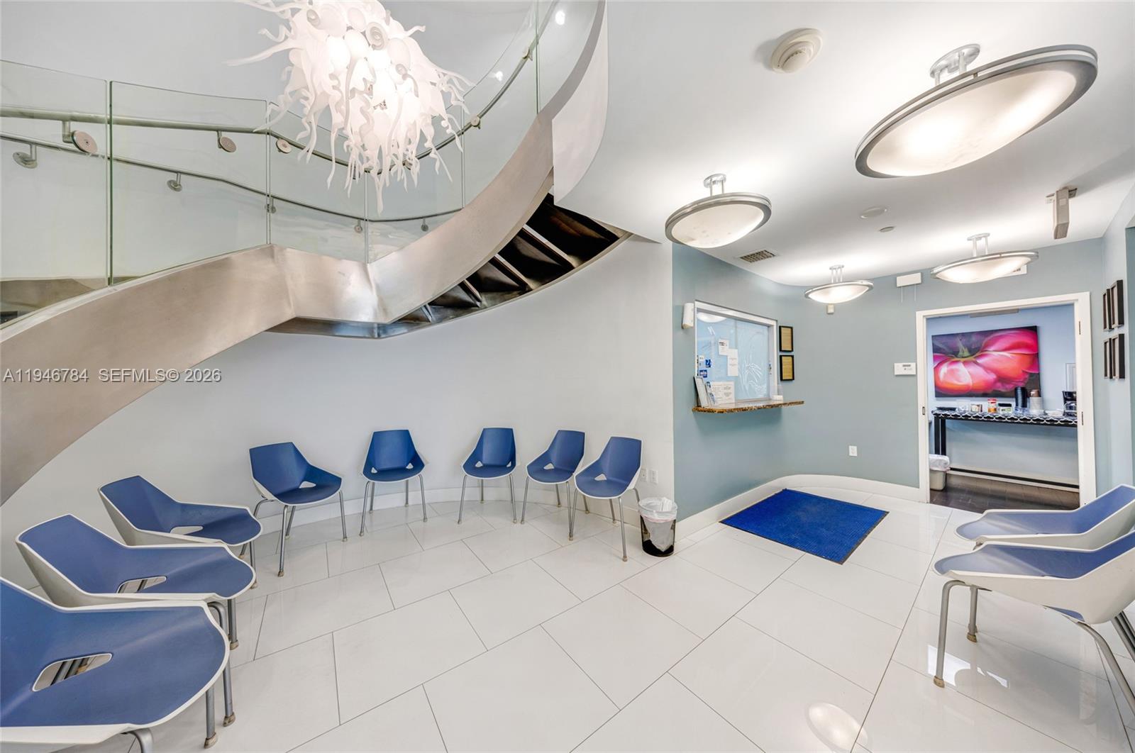 A waiting room features blue chairs, white tile floors, and a curved metal staircase — 1693 SW 27th Ave, Miami FL 33145, MIAMI, FL
