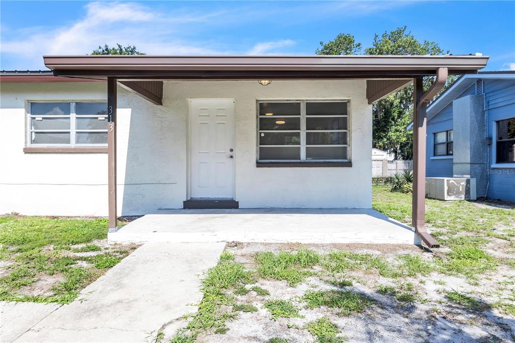 A single-story house exterior features a white stucco facade, a covered porch, and horizontal windows — 311 & 313 N ARCADIA AVENUE, ARCADIA, FL
