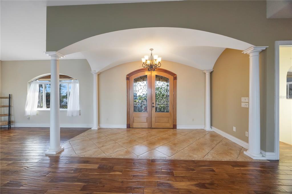 An entryway features a tiled floor, arched ceiling, white columns, and double wooden doors — 736 PRUITT DRIVE, MADEIRA BEACH, FL