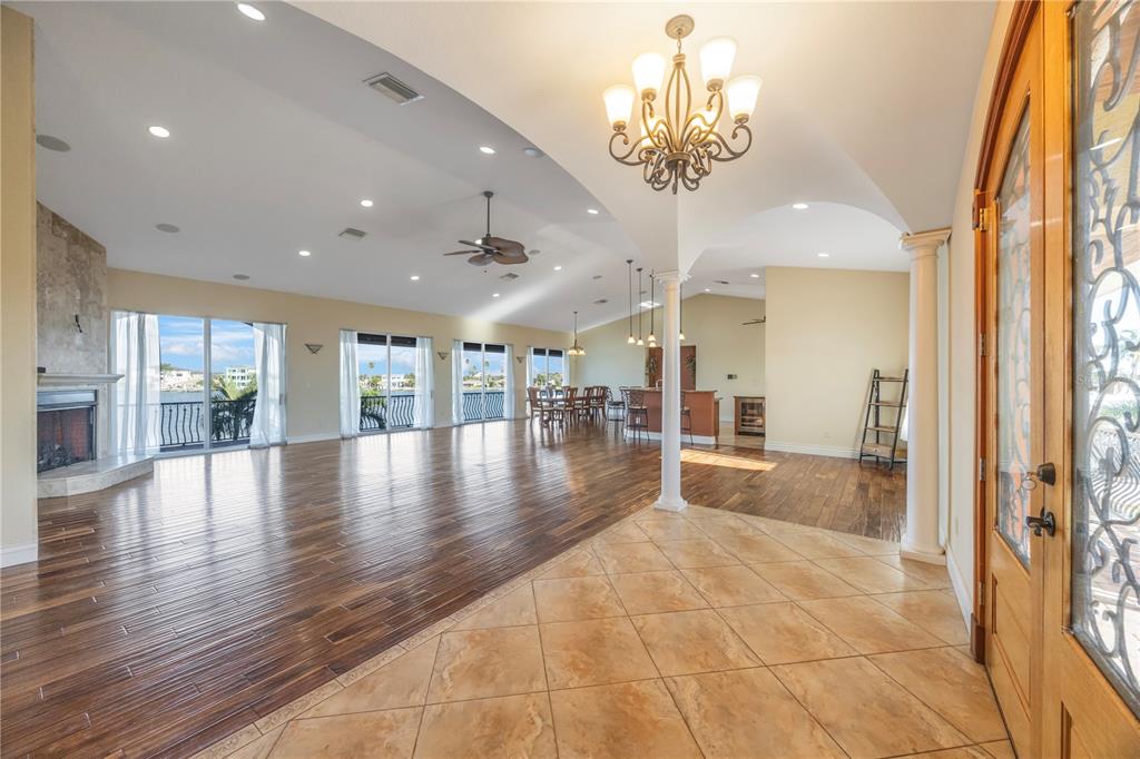 An open-concept living area features hardwood floors, a stone fireplace, and a tiled entryway — 736 PRUITT DRIVE, MADEIRA BEACH, FL