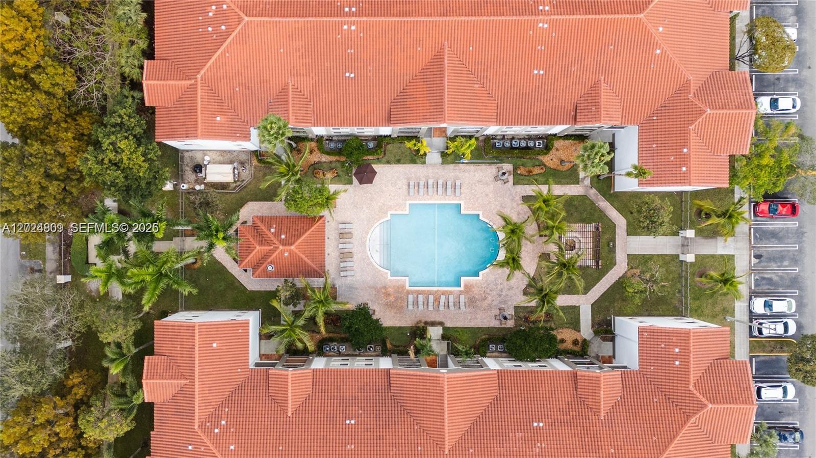 An aerial view shows a swimming pool surrounded by a courtyard and apartment buildings — 6851 SW 44th St # 207, Miami FL 33155, MIAMI, FL