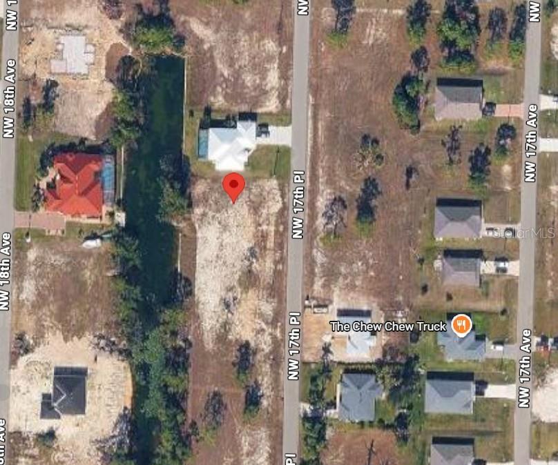 This aerial map shows a vacant residential lot situated between a canal and a road — 3112 NW 17TH PLACE, CAPE CORAL, FL