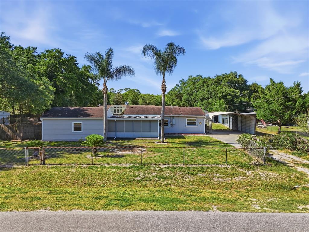 A single-story house with light gray siding, a screened porch, and two tall palm trees — 17753 EVANS TRAIL, ORLANDO, FL
