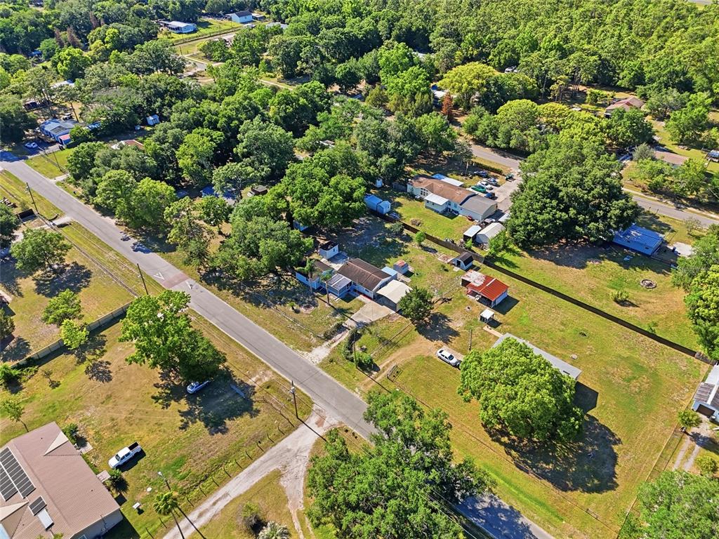 An aerial view shows a residential property with a house, outbuildings, and trees along a road — 17753 EVANS TRAIL, ORLANDO, FL