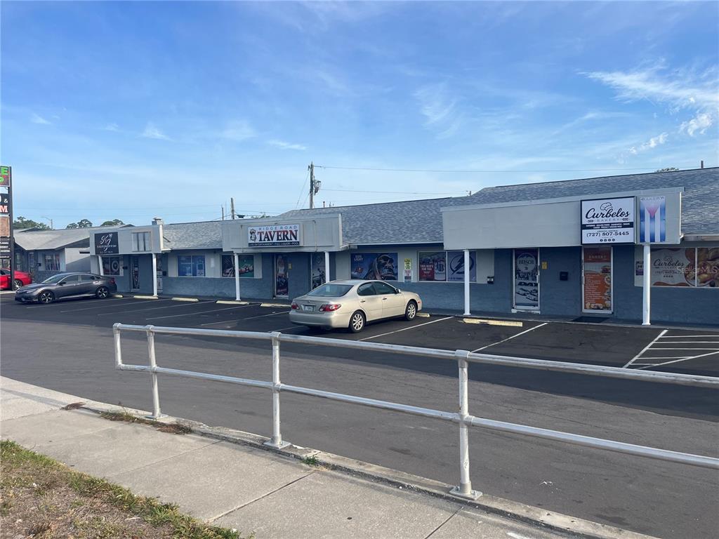 A single-story commercial strip mall features a tavern and a bakery with a parking lot — 6201 RIDGE ROAD, PORT RICHEY, FL