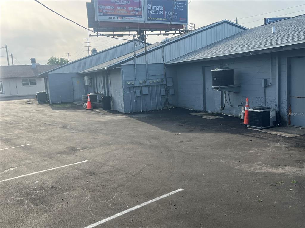 The exterior of a gray commercial building features a parking lot and several HVAC units — 6201 RIDGE ROAD, PORT RICHEY, FL