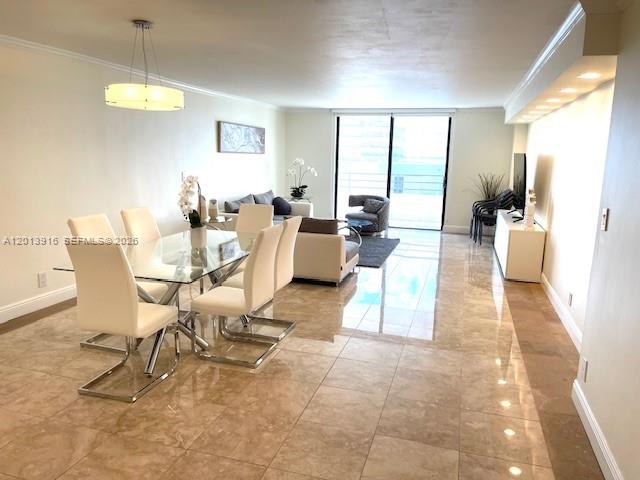 A dining and living area features tile flooring, a glass table, and a balcony view — 2500 Parkview Dr # 2114, Hallandale Beach FL 33009, HALLANDALE BEACH, FL