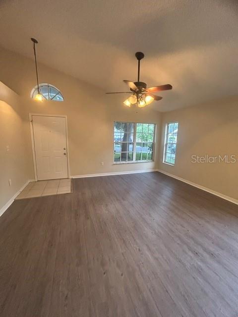 An empty living room features wood-look flooring, a ceiling fan, and a front entry door — 816 SHELL LANE, LONGWOOD, FL