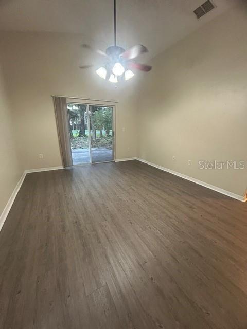 An empty room features light-colored walls, wood-look flooring, a ceiling fan, and sliding glass doors — 816 SHELL LANE, LONGWOOD, FL