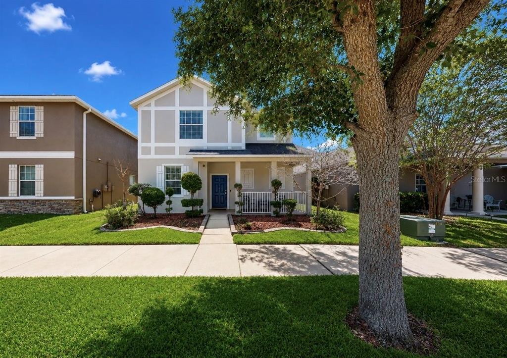 A two-story house with a blue front door, a covered porch, and a front lawn — 12020 STREAMBED DRIVE, RIVERVIEW, FL