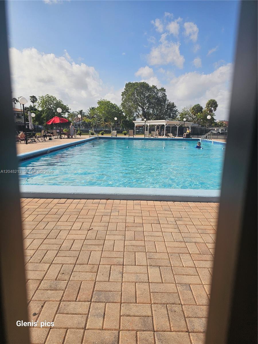 A rectangular swimming pool is surrounded by a brick paver deck and outdoor seating area — 801 Three Islands Blvd # 218, Hallandale Beach FL 33009, HALLANDALE BEACH, FL