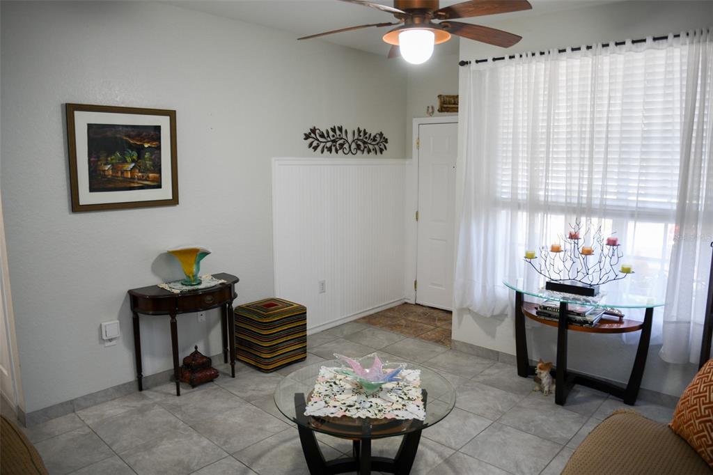 A living room with tile flooring, a ceiling fan, and a glass-topped coffee table — 830 GRAND REGENCY POINT UNIT 101, ALTAMONTE SPRINGS, FL