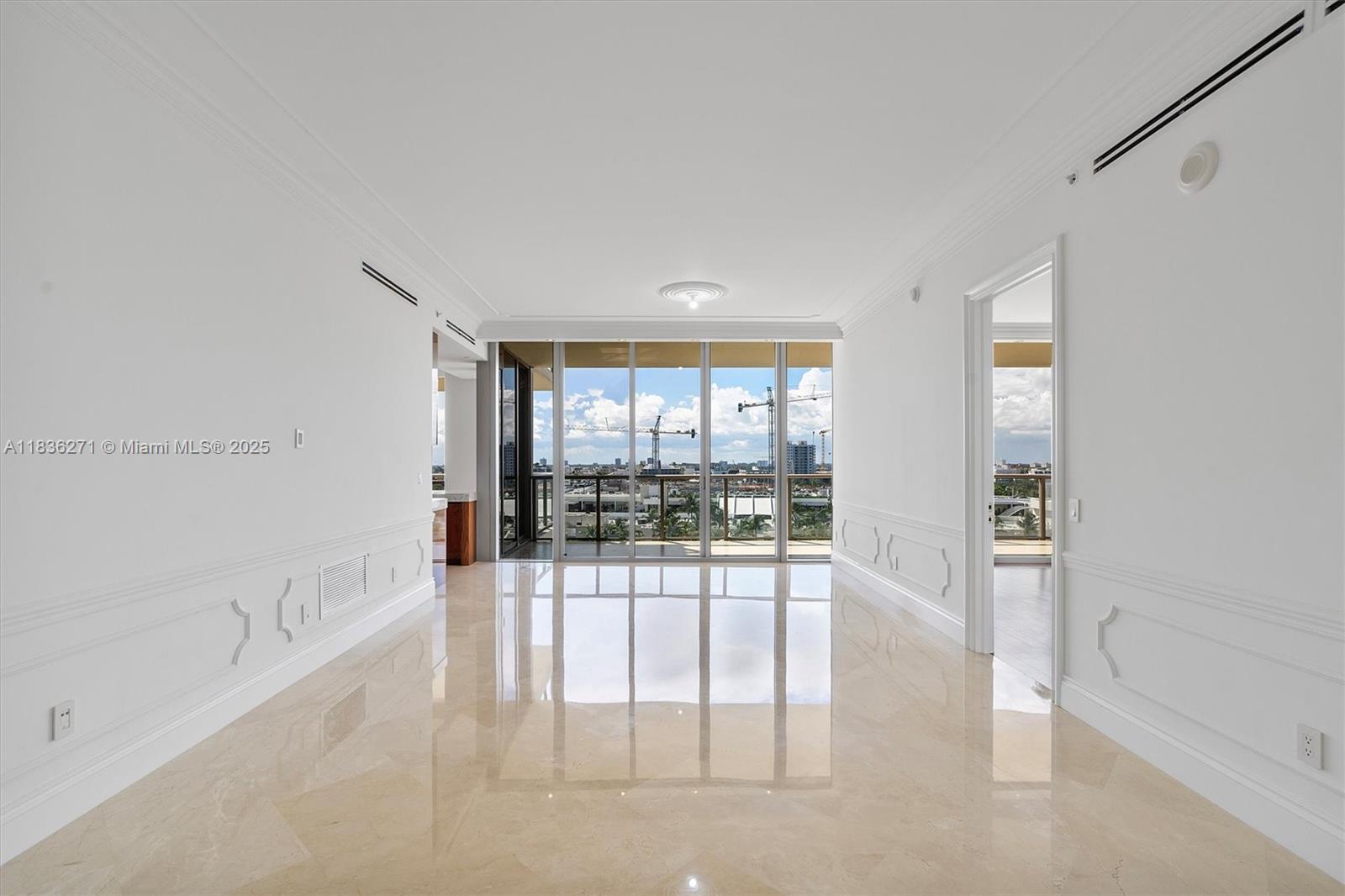 A bright, empty room features polished marble floors, white paneled walls, and floor-to-ceiling windows — 9701 Collins Ave # 802S, Bal Harbour FL 33154, BAL HARBOUR, FL