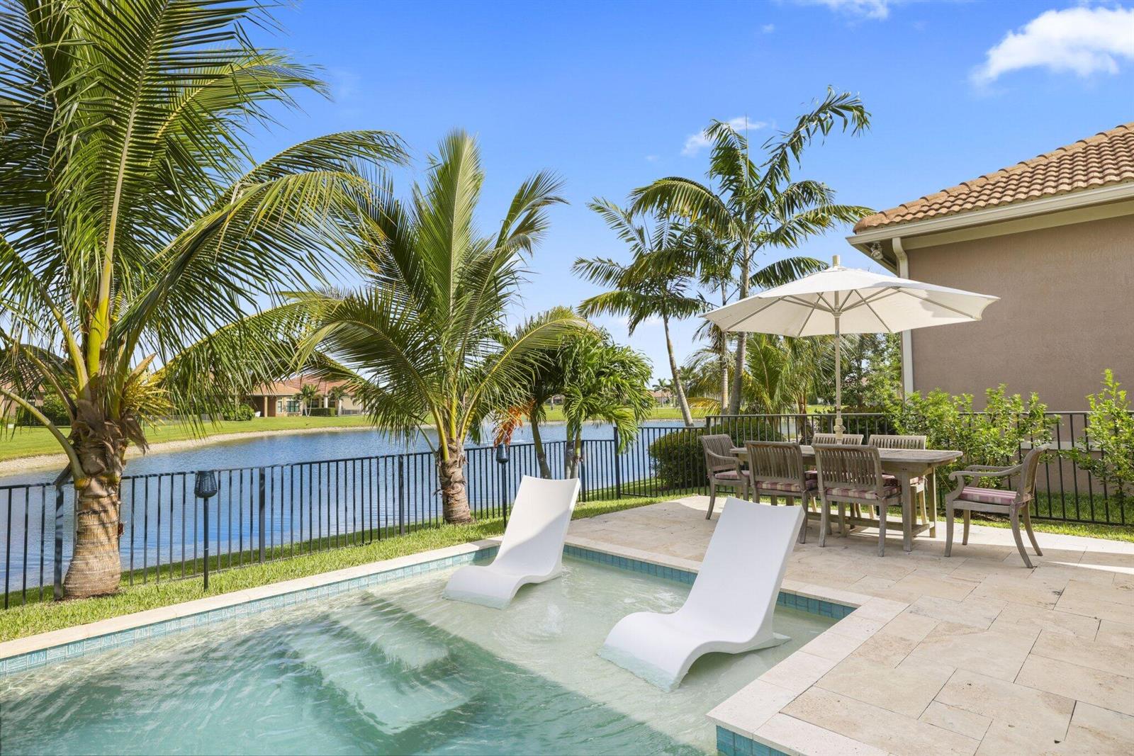 A patio features a small pool with two lounge chairs, a dining set, and palm trees — 9031 Leon Circle W, Parkland FL 33076, PARKLAND, FL