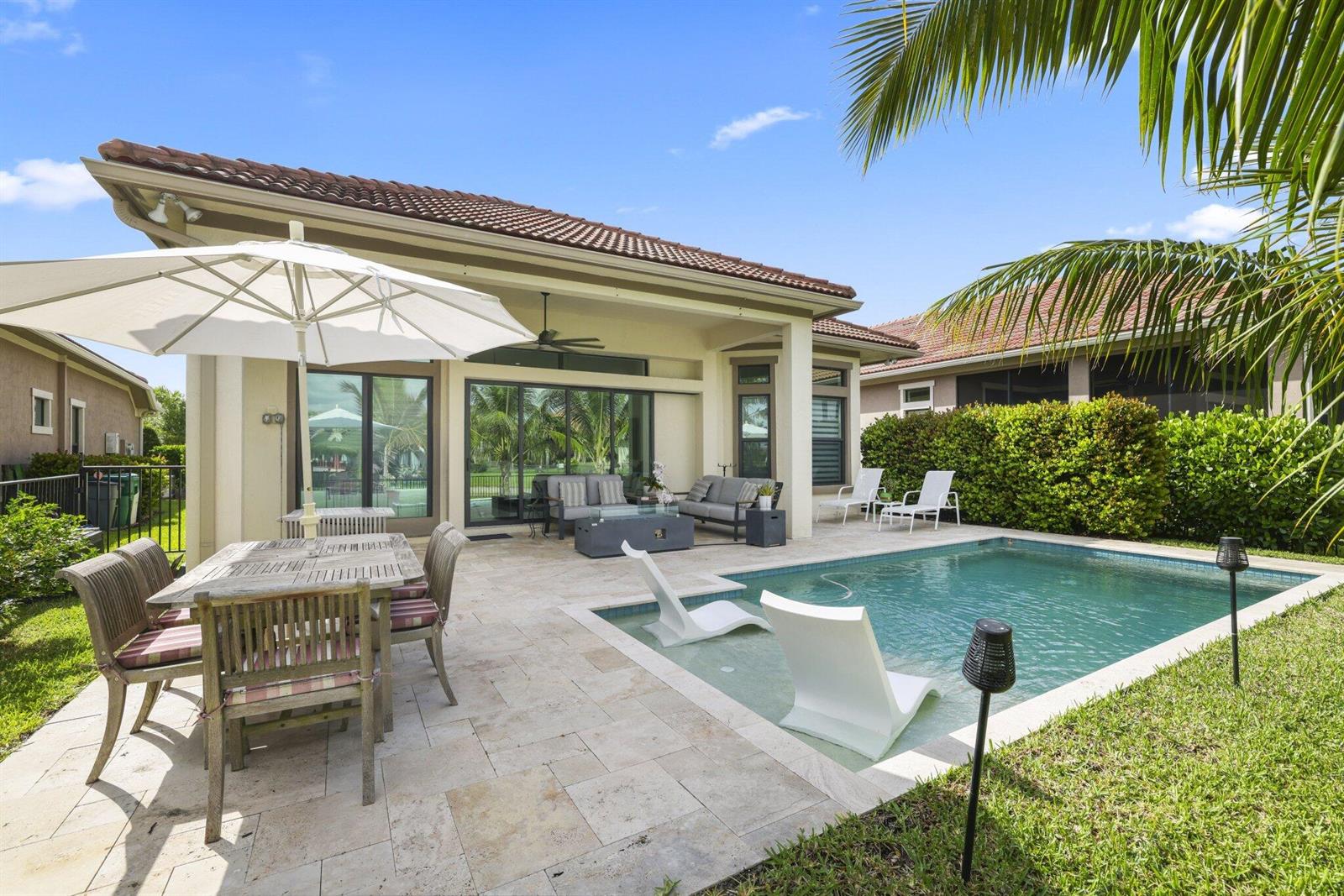 A backyard patio features a dining set, lounge furniture, and a swimming pool with loungers — 9031 Leon Circle W, Parkland FL 33076, PARKLAND, FL