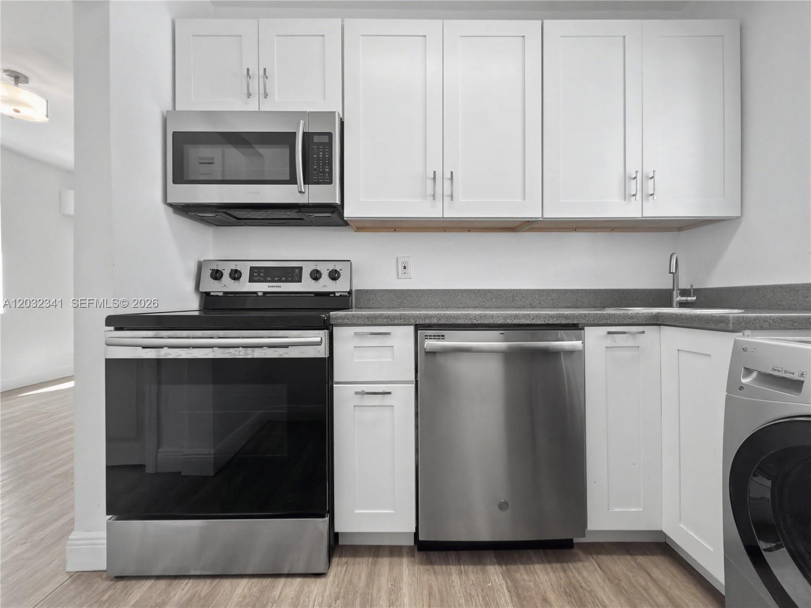 A kitchen features white cabinetry, stainless steel appliances, and gray countertops — 350 Minorca Ave # 2, Coral Gables FL 33134, CORAL GABLES, FL