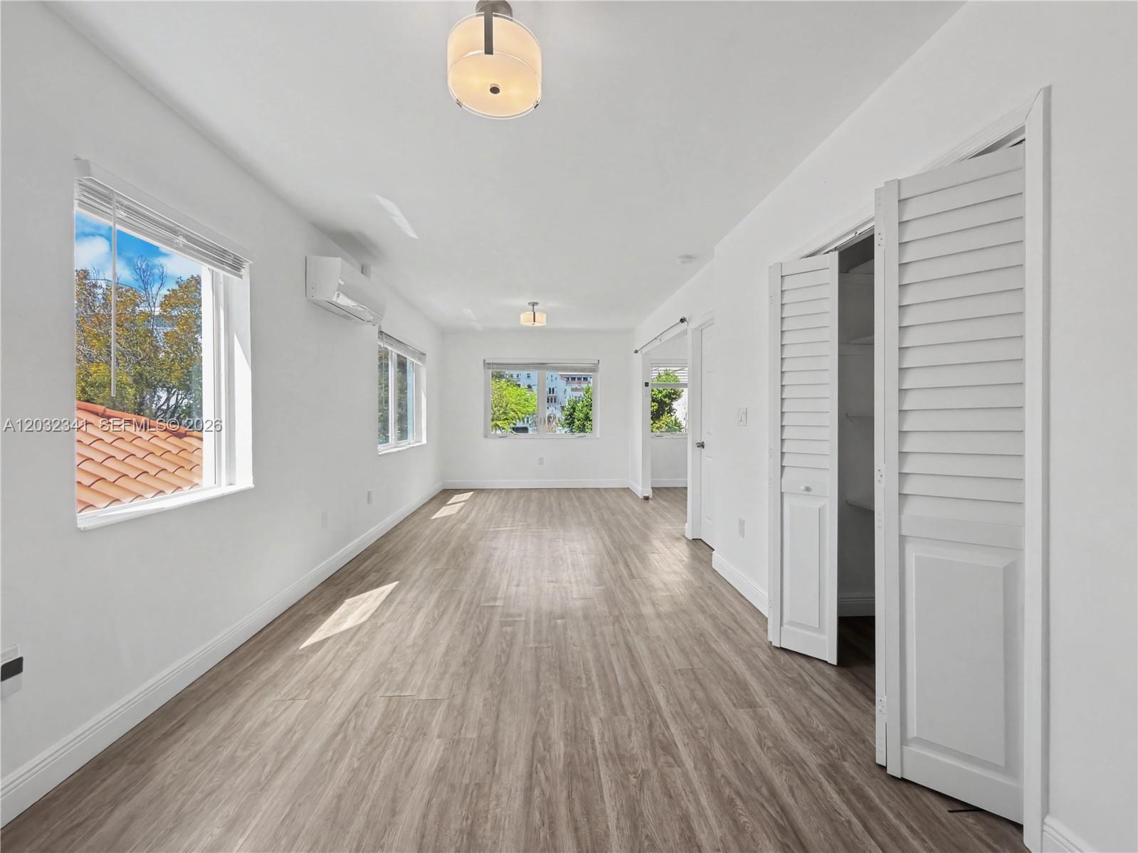 An empty room features white walls, light wood-look flooring, a ceiling light, and a closet — 350 Minorca Ave # 2, Coral Gables FL 33134, CORAL GABLES, FL