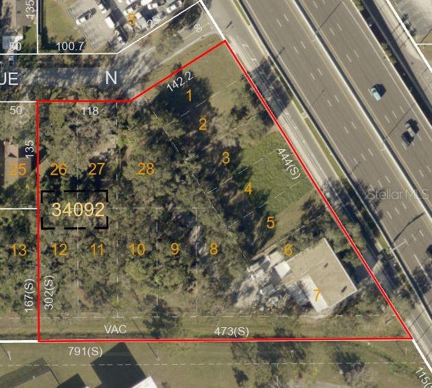 This is an aerial map showing a large, irregularly shaped parcel of land with numbered lots — 11400 US HIGHWAY 19 N, CLEARWATER, FL