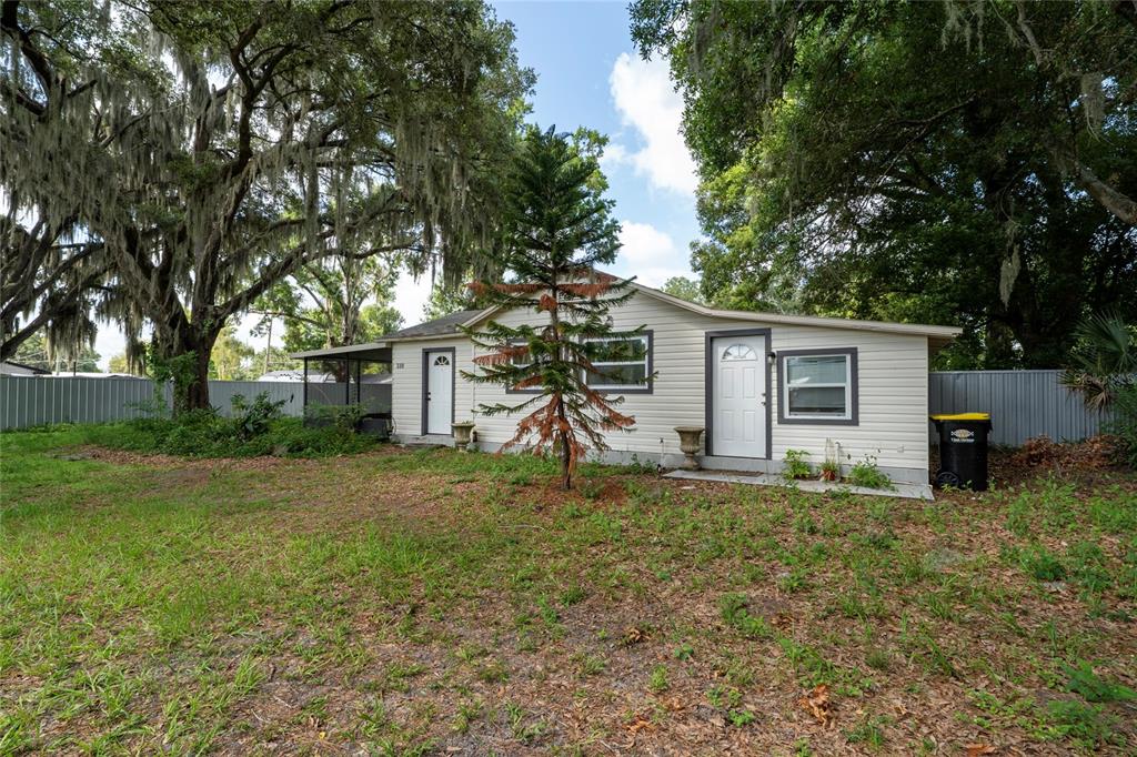 A single-story house with light-colored siding, two doors, and a small tree in the yard — 310 CORDOVA ROAD, AUBURNDALE, FL