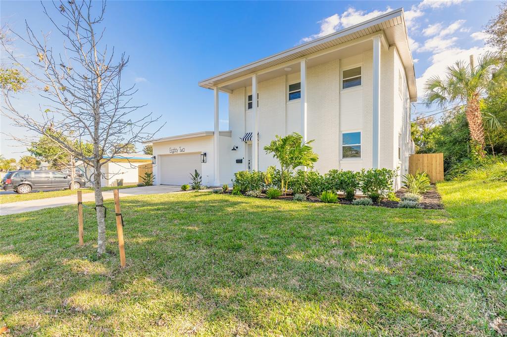 A two-story white house with a garage and a front lawn under a blue sky — 82 RAY MAR DRIVE, ORMOND BEACH, FL