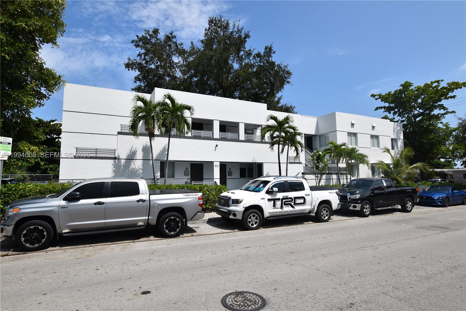 A two-story white apartment building with palm trees and parked trucks in front — 835 SW 8th Ave, Miami FL 33130, MIAMI, FL