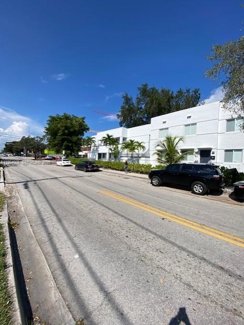 A black SUV is parked on the street in front of a white multi-story building — 835 SW 8th Ave, Miami FL 33130, MIAMI, FL