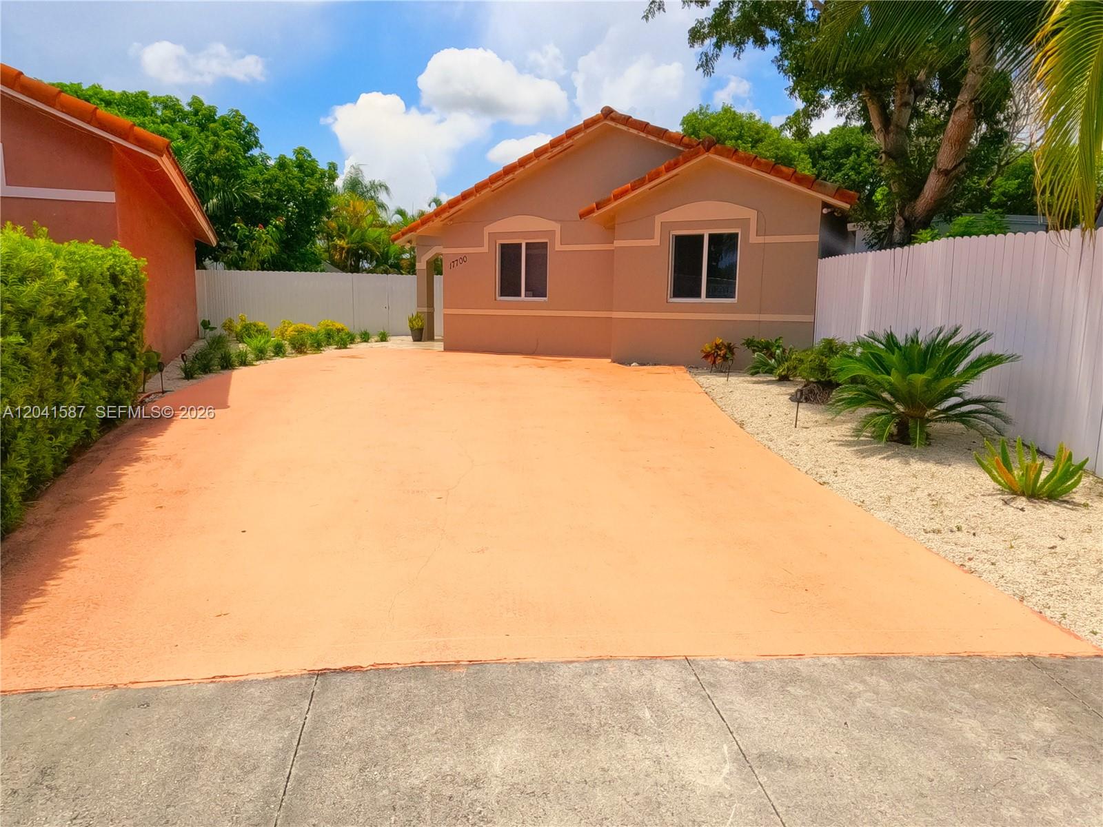 A single-story house with a terracotta tile roof and a large orange-painted driveway — 17700 SW 145th Ave, Miami FL 33177, MIAMI, FL