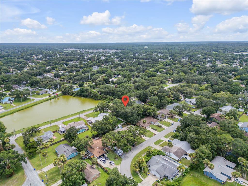 An aerial view shows a residential neighborhood with a red location pin over a house — 1205 16TH STREET, EDGEWATER, FL