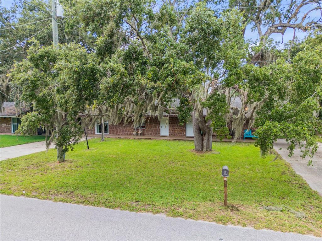 A single-story brick house with a large front yard and mature oak trees — 1205 16TH STREET, EDGEWATER, FL