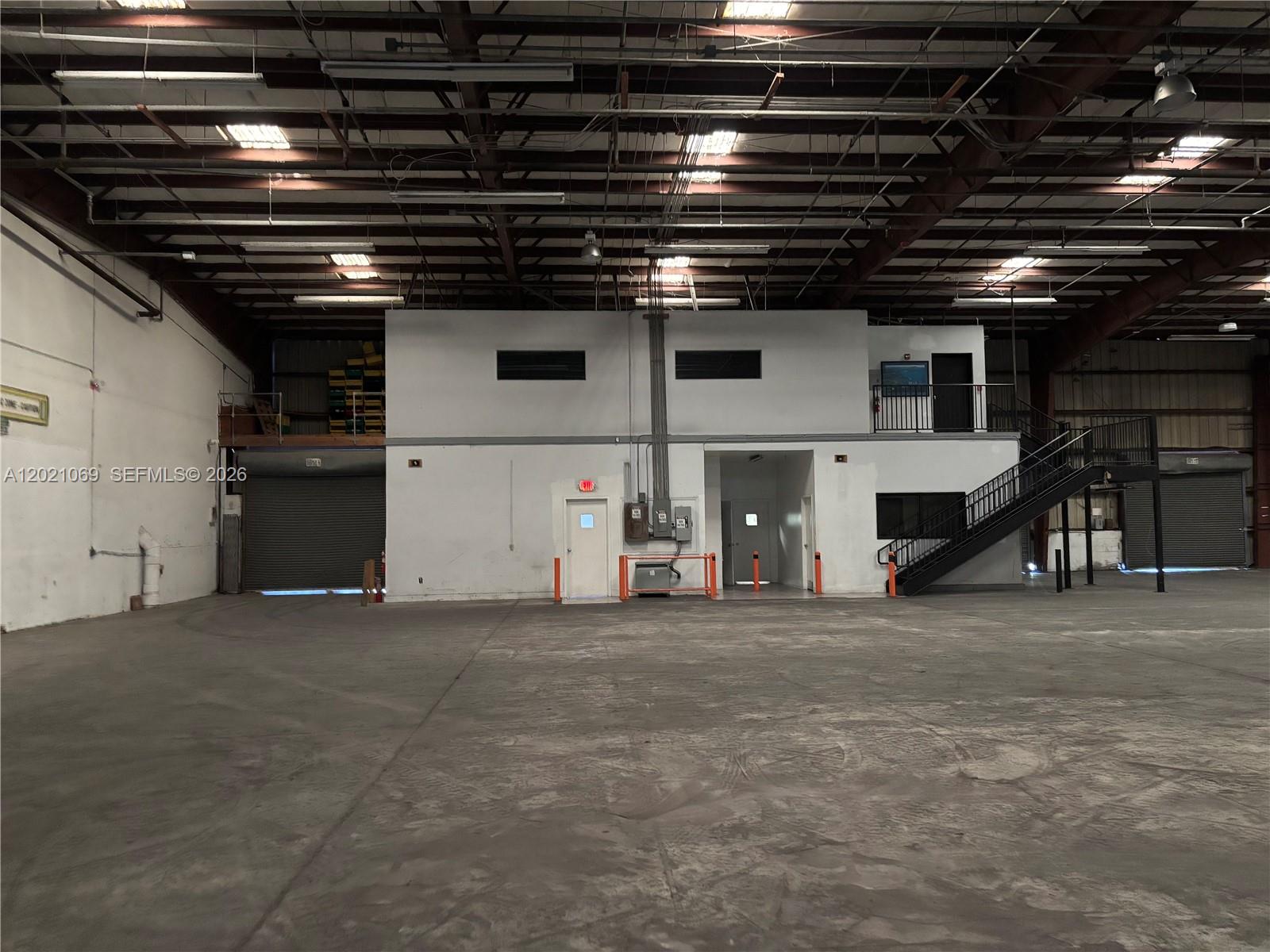 A large industrial warehouse space features a central two-story office structure with stairs — 50 NE 179th St., Miami Gardens FL 33162, MIAMI GARDENS, FL