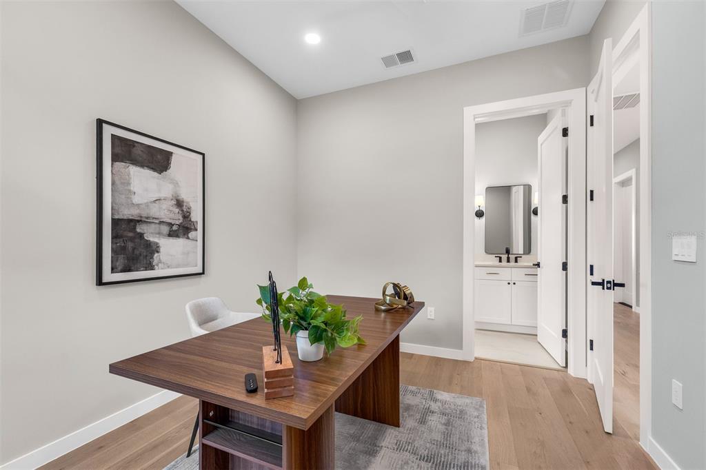 A modern home office features a wood desk, a potted plant, and an attached bathroom — 9 E STEELE STREET, ORLANDO, FL