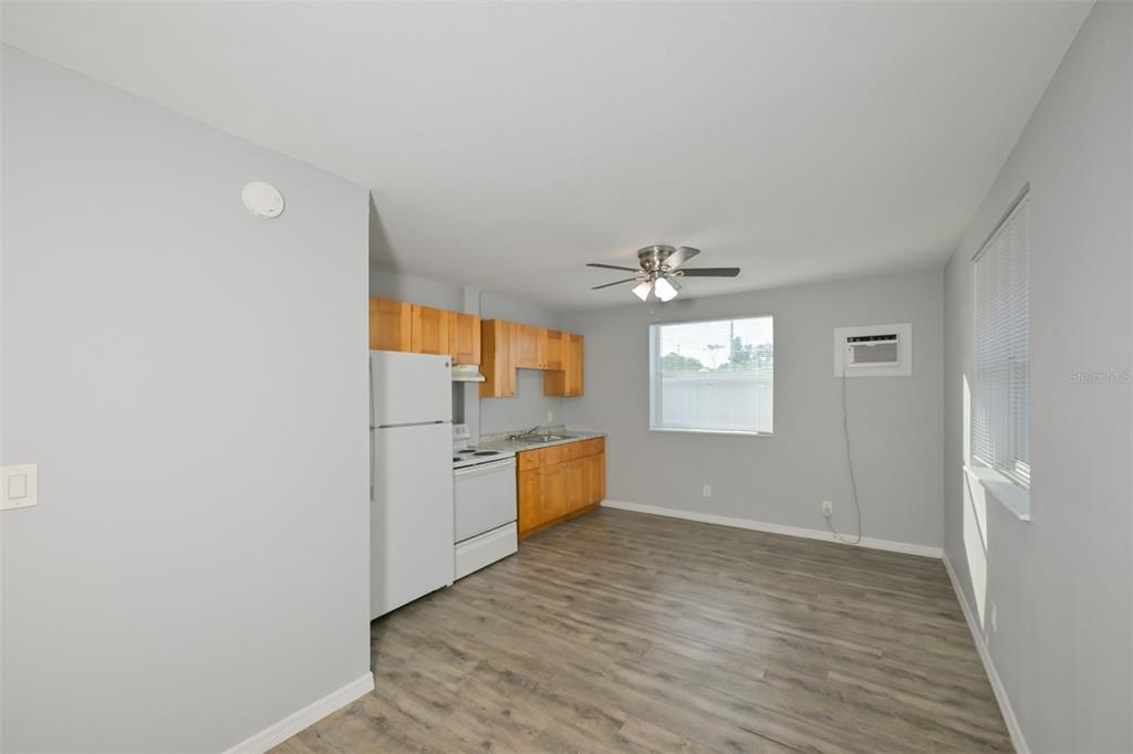 A kitchen with light wood cabinets, white appliances, and gray wood-look flooring — 1956 MCMULLEN ROAD UNIT 2, LARGO, FL