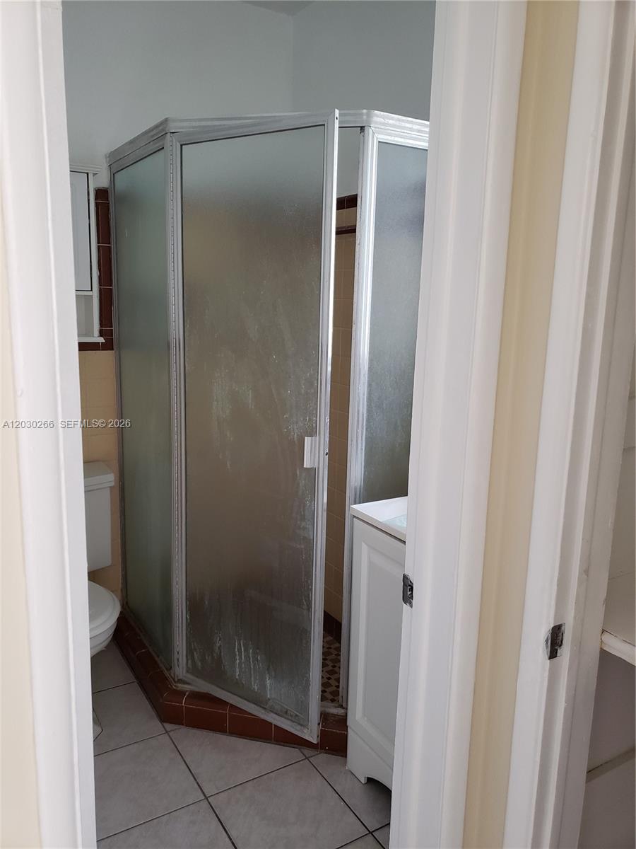 A bathroom features a corner shower stall with frosted glass doors and tiled flooring — 1821 SW 7th St # 7, Miami FL 33135, MIAMI, FL