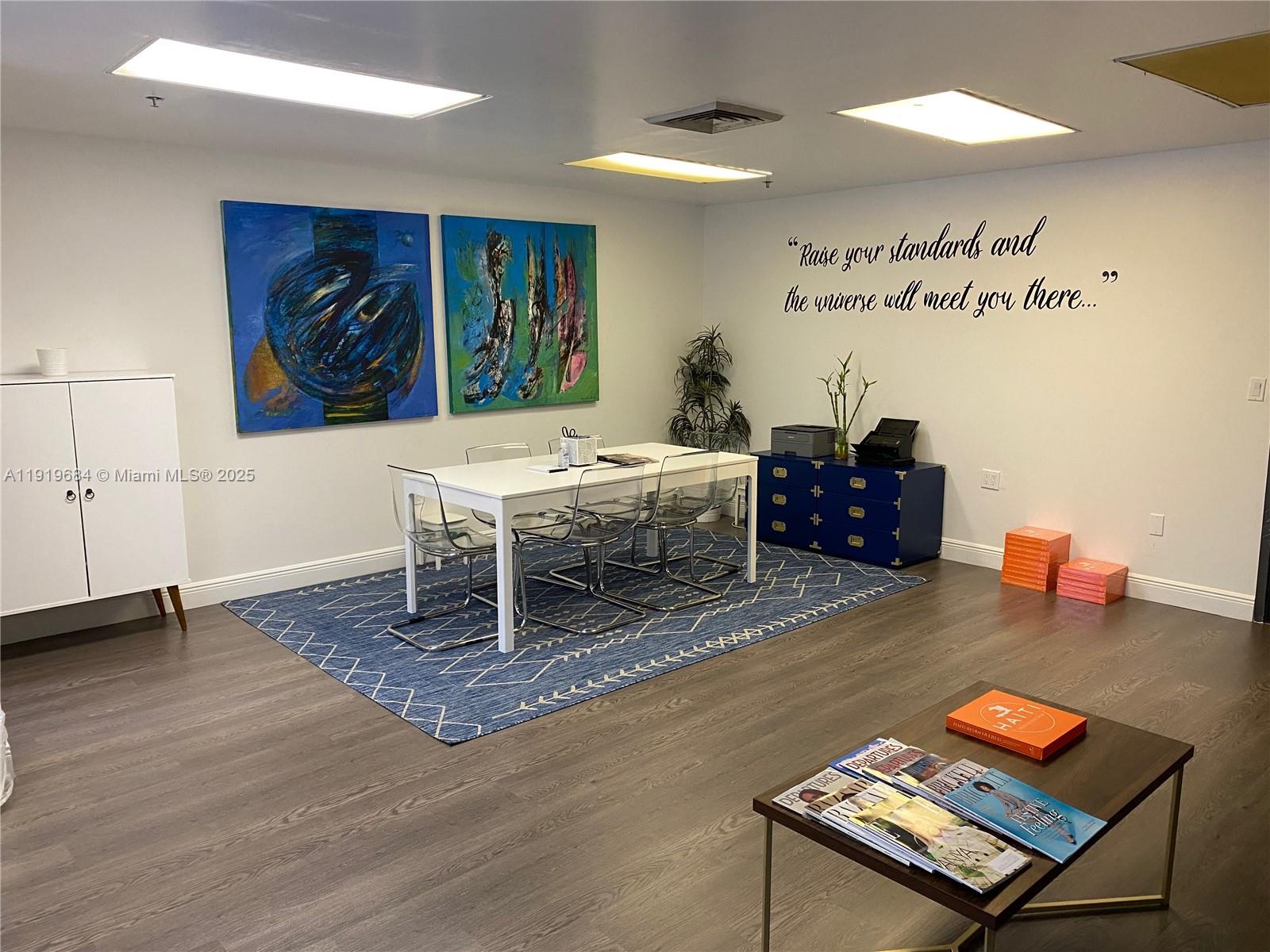 A modern office space features a white conference table, blue area rug, and wall art — 1110 Brickell Ave # 313, Miami FL 33131, MIAMI, FL